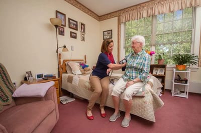 Caregiver assisting a resident in their room.