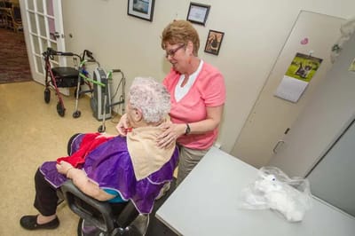 Resident receiving a hair styling in the facility.