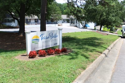 Sign for TerraBella Senior Living with landscaped area