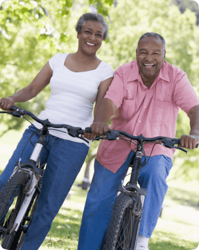 Older couple enjoying biking in a park
