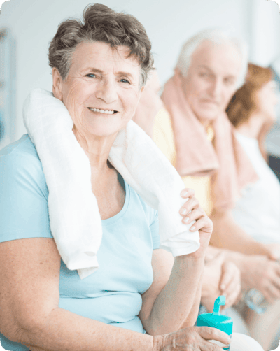 Smiling senior woman with a towel seated in common area