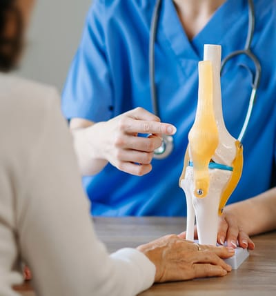 Healthcare professional explaining joint anatomy to a patient.