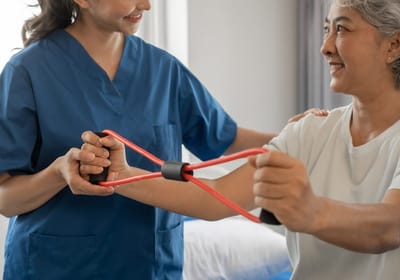 Staff assisting a resident with rehabilitation exercises.