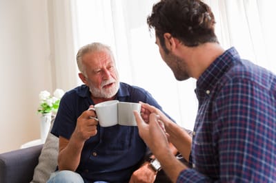 Two men enjoying coffee together indoors.