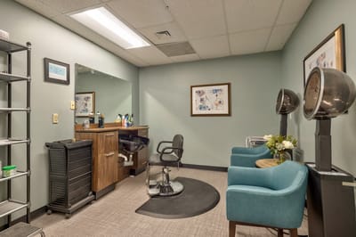 Salon area with hair styling chairs and equipment.