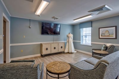 Cozy common area with seating and a dress display.