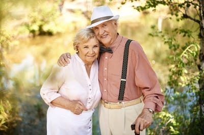 Happy senior couple outdoors by the water