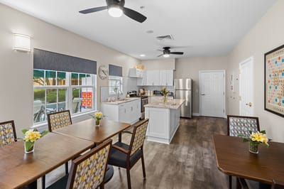 Bright communal kitchen area with tables and chairs