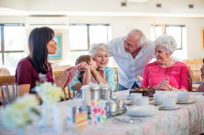 Residents celebrating with staff and family at a table