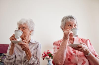 Two elderly women enjoying tea together
