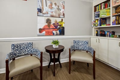 Comfortable seating in a common area with residents engaging in activity.