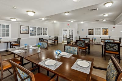Dining room with tables and flowers, ready for meals.