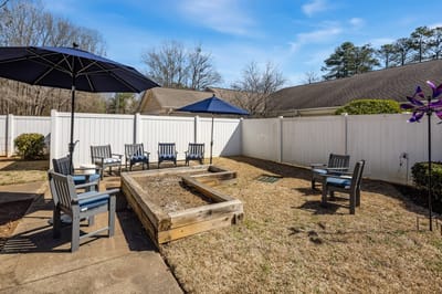 Outdoor seating area with garden beds and umbrellas