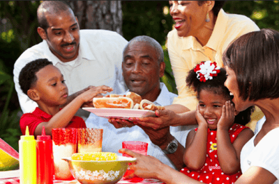 Family gathering outdoors with food and children.