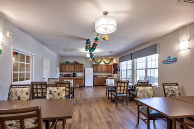 Common area with tables and kitchen in the background
