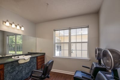 Hair salon area with styling chairs and mirror