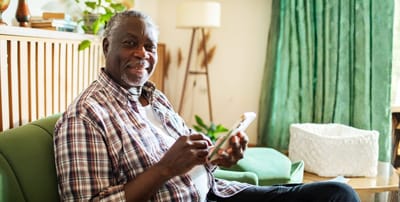 Senior man using a tablet in a cozy sitting area.
