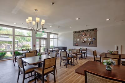 Common area with tables and a Wall of Valor display.