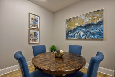 Cozy dining space with artwork and a wooden table.