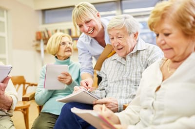 Residents engaging in a creative activity with staff guidance.