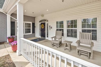 Front entrance area with seating and flower pots.