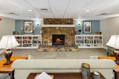 Cozy common area with fireplace and bookshelves.