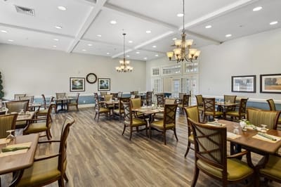 Dining area with tables and chairs set for guests.