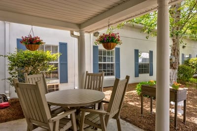 Outdoor seating area with hanging flower baskets.
