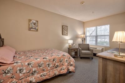Cozy resident room with bed and seating area.