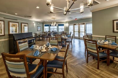 Dining area with tables and chairs set for a meal.