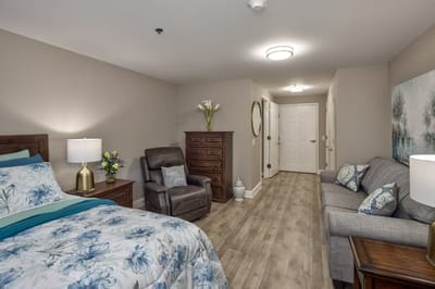 Cozy resident room with bed and sitting area.
