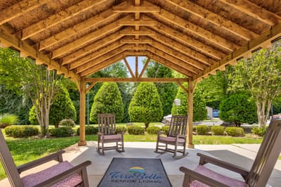Outdoor seating area with rocking chairs and landscaped garden