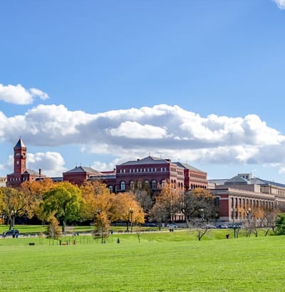 Exterior view of a large building with a green field.