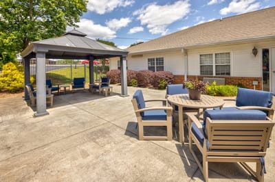 Outdoor seating area with gazebo and chairs.