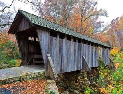 A covered bridge surrounded by autumn trees