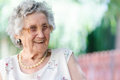 Elderly woman smiling in a natural setting