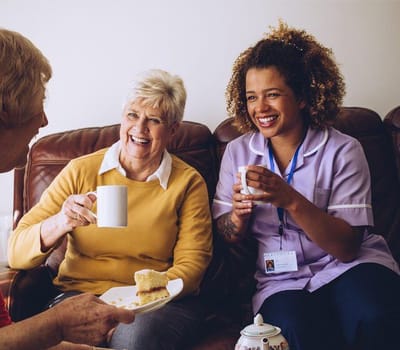 Residents enjoying tea and cake with staff.