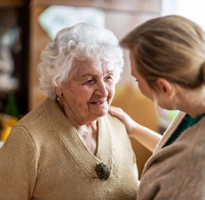 Elderly woman conversing with caregiver indoors