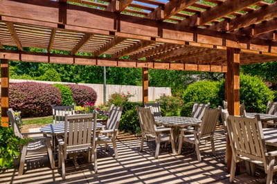 Outdoor patio with chairs and tables under pergola