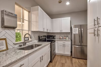Modern kitchen with white cabinets and stainless appliances