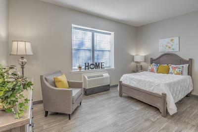 Cozy resident room with bed and seating area.