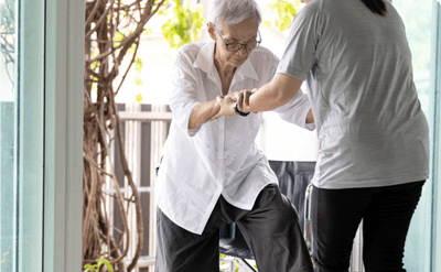 Staff assisting a resident in a bright indoor space