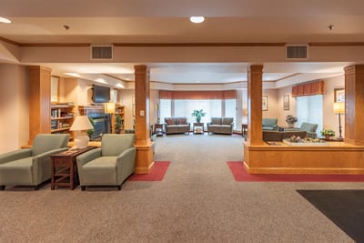 Common area with seating and fireplace in a senior living facility