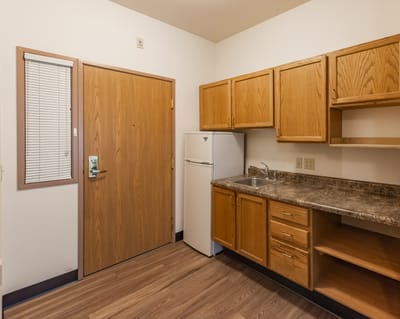 Interior view of a small kitchen area with wooden cabinets