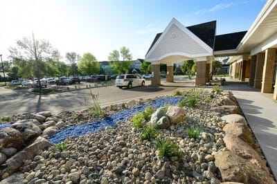 Exterior view of a senior living facility entrance with landscaped garden.