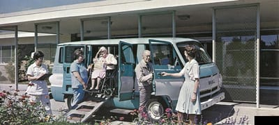 Transport van assisting elderly resident outdoors