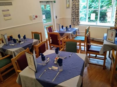 Dining area with set tables and blue tablecloths.