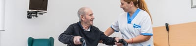 Staff assisting a resident in a room.