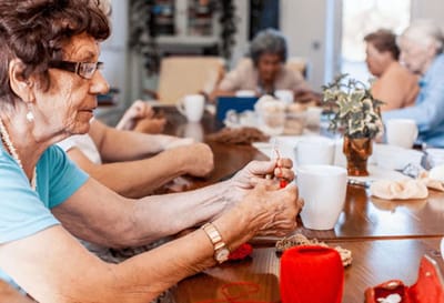 Residents enjoying a craft activity at a table.