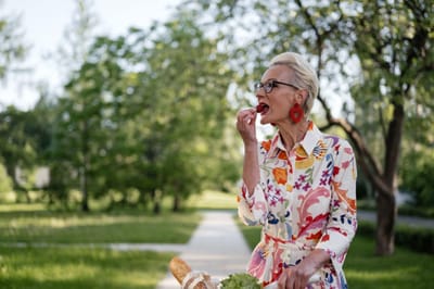 Senior woman enjoying fresh food outdoors.